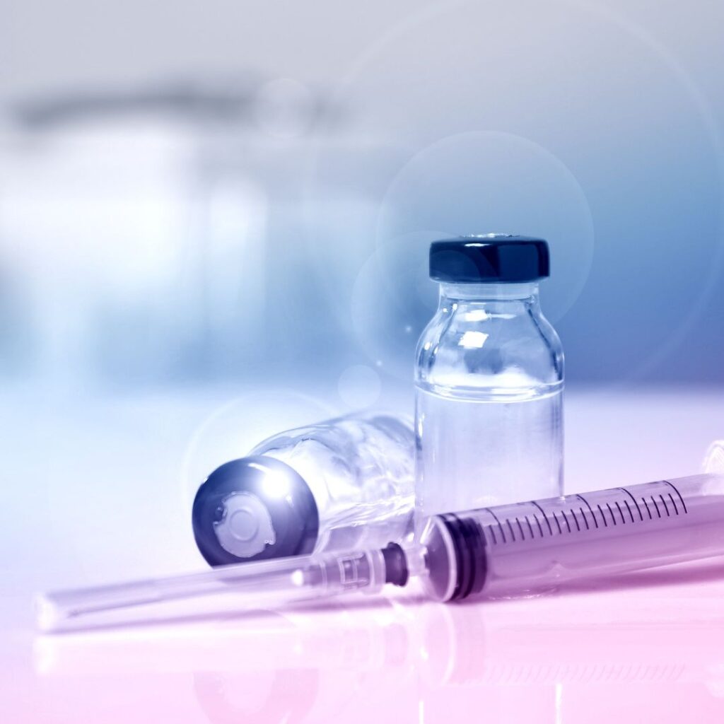 A picture of a vaccine bottles and syringe